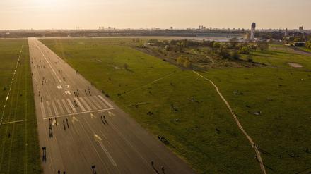 Menschen sind während des Sonnenuntergangs auf dem Tempelhofer Feld unterwegs. Seit einigen Monaten hat die Debatte um eine Randbebauung wieder an Fahrt aufgenommen.