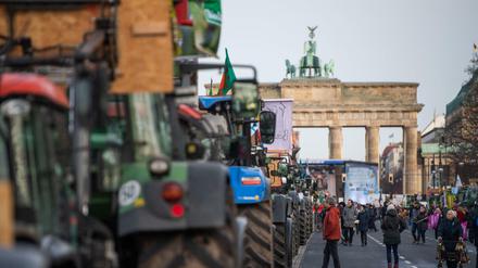 Bauern stehen mit ihren Traktoren auf der Straße des 17. Juni vor dem Brandenburger Tor.