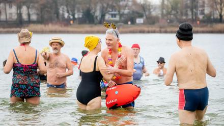 Winterschwimmer des Vereins „Berliner Seehunde“ stehen beim Neujahrsschwimmen im Orankesee.