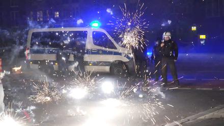 Berliner Polizisten vor einem explodierenden Feuerwerk