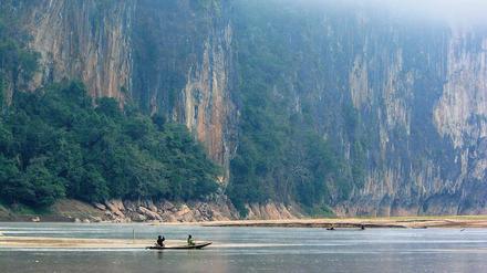 Abhang. Steile Felsen und grüne Hügel prägen die Ufer des Mekong.