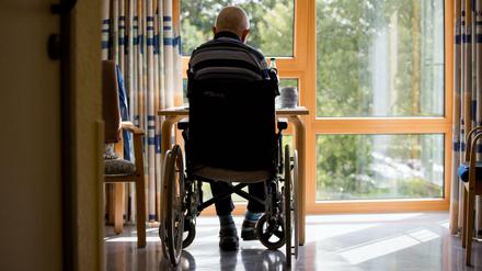  Ein in einem Rollstuhl sitzender Bewohner sitzt in einem Altenpflegeheim in seinem Zimmer.
