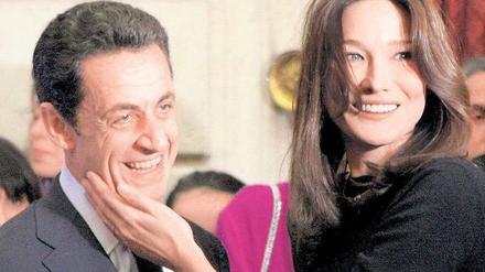 Schöne Bilder, zur richtigen Zeit gesetzt. Frankreichs Präsident Nicolas Sarkozy und Ehefrau Carla Bruni-Sarkozy bei einer Weihnachtsfeier im Elysee-Palast. Foto: dpa
