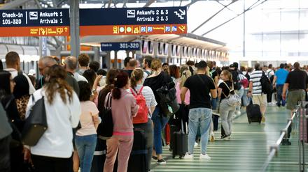 Passagiere stehen in einer Schlange für die Sicherheitskontrolle am Flughafen Köln-Bonn an.