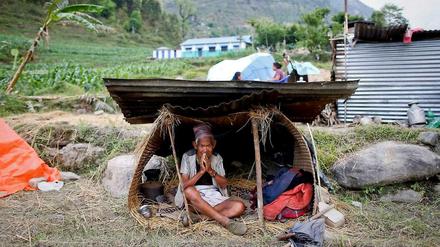 Ein Nepalese sitzt in einer selbsgebastelten Unterkunft, nachdem er sein Haus durch das große Erdbeben verloren hatte.
