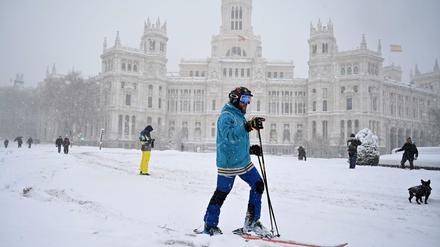 Ein Mann fährt auf Skiern durch das Zentrum von Madrid.
