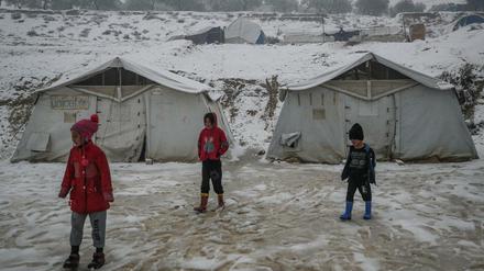 Syrische Kinder stehen in einem verschneiten Lager für syrische Binnenvertriebene. Der Wintereinbruch trifft sie am härtesten. 