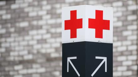  Ein Schild mit einem roten Kreuz weist den Weg zur Notaufnahme.