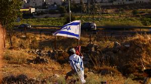 Ein Junge mit Israelflaggen demonstriert für die Gründung einer neuen Siedlung nahe Hebron im Westjordanland.