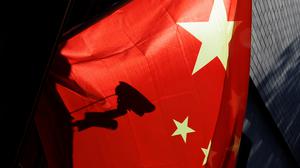 Eine Überwachungskamera hinter einer chinesischen Nationalflagge i Peking.