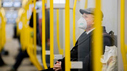 Ein Mann sitzt mit FFP2-Maske in der U-Bahn. In Berlin ist das im ÖPNV vorgeschrieben. 