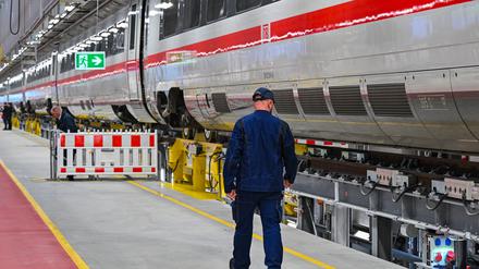 Ein Mitarbeiter der Deutschen Bahn geht an einem ICE des DB-Instandhaltungswerks für ICE 4-Züge vorbei. 