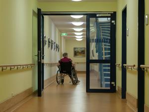 Eine Bewohnerin des Pflegeheims rollt im Rollstuhl durch den Flur Flur im Pflegeheim *** A resident of the nursing home rolls through the hall in a wheelchair 