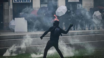 Ein Demonstrant in Nante, holt zum Flaschenwurf aus.