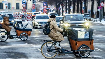 Frauen mit Lastenfahrrädern überqueren die Prinzregentenstraße, München im Januar 2024.