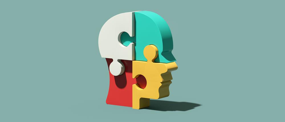 Verschiedenfarbige Puzzlesteine bilden einen dreidimensionalen menschlichen Kopf.