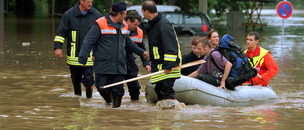 Feuerwehrmänner bergen Dresdner Einwohner im Schlauchboot aus der überschwemmten Stadt.
