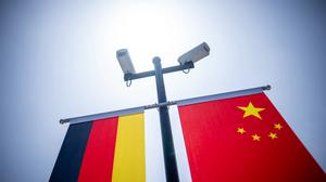 Überwachungskameras sind über der deutschen und der chinesischen Flagge vor der Tongji-Universität montiert