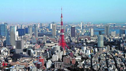 ARCHIV - Die Skyline von Tokio, in der Mitte der Tokyo Tower - mit einer Höhe von 332,6 Metern einer der höchsten selbsttragenden, aus Stahl bestehenden Türme der Welt (Archivfoto vom 14.02.2005). Entgegen dem Klischee sind die meisten Häuser in der Hauptstadt Japans nur zweistöckig. Dazwischen ragen jedoch zunehmend hochmoderne riesige Geschäfts- und Wohnkomplexe in den Himmel. Foto: Andy Rain/EPA (zu dpa: "Die Grenzen der Stadt" vom 16.10.2016) +++(c) dpa - Bildfunk+++ |