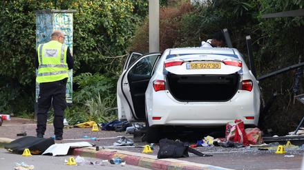 Israelische Rettungskräfte arbeiten neben einem beschädigten Auto nach einem Rammangriff in Ra’anana. 