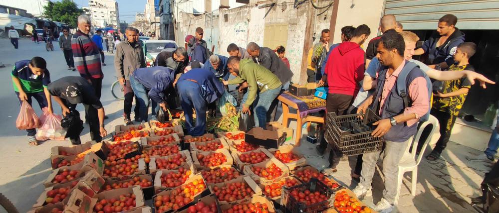 Palästinenser kaufen Gemüse und andere Lebensmittel auf einem Markt.