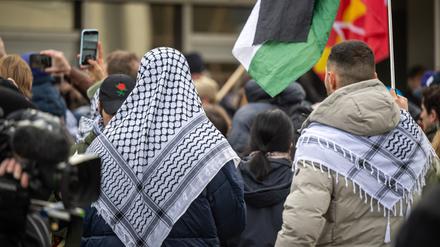 Teilnehmer der propalästinensischen Kundgebung unter dem Motto „Solidarität mit Palästina“ stehen mit Palästinenser-Tüchern und Flaggen vor der Mensa II an der Freien Universität (FU). Die Uni steht von mehreren Seiten in der Kritik, nachdem ein jüdischer Student am Wochenende von seinem propalästinensischen Kommilitonen geschlagen und getreten wurde. 