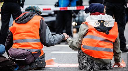 dpatopbilder - 05.12.2022, Bayern, München: Aktivisten der Klimaschutz-Initiative ·Letzte Generation· haben sich am Stachus mit ihren Händen auf die Straße geklebt. Foto: Matthias Balk/dpa +++ dpa-Bildfunk +++