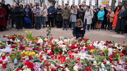 Menschen stehen nach dem Tod des Regimekritikers Alexej Nawalny vor der russischen Botschaft in Berlin-Mitte vor Blumen.