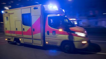 Ein Rettungswagen fährt mit Blaulicht nachts durch die Stadt.