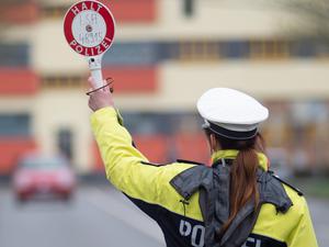 Sachsen-Anhalt, Magdeburg: Eine Polizistin winkt mit einer Kelle ein Auto von der Straße (Archivbild vom 03.04.2019).