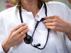 Eine Ärztin trägt in einem Krankenhaus ein Stethoskop um den Hals. 