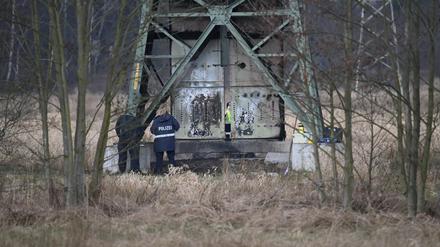 Polizei ermittelt an einem beschädigten Strommasten auf einem Feld bei Spreenhagen. 