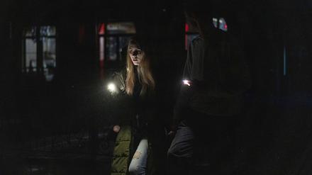 Ein junges Paar spaziert durch das Stadtzentrum, das nach einem russischen Raketenangriff am Tag zuvor ohne Strom ist.