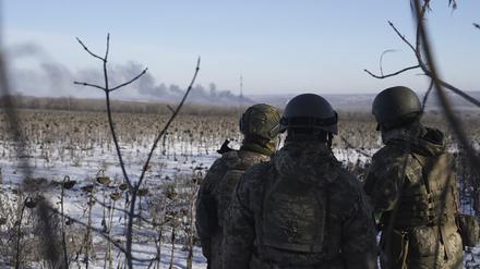 Ukrainische Soldaten blicken während der Kämpfe zwischen ukrainischen und russischen Truppen auf aufsteigende Rauchwolken. Der Kreml hat die Einnahme der Stadt Soledar in der Ostukraine nicht offiziell bestätigt, aber von einer „positiven Dynamik“ gesprochen. 