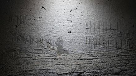 Blick auf Ziffern, die zur Zeitmessung von Häftlingen in die Wand eines Kellers in einem Gebäude geritzt wurden, das nach Angaben eines Staatsanwalts für Kriegsverbrechen von russischen Streitkräften als Folterstätte genutzt wurde. 