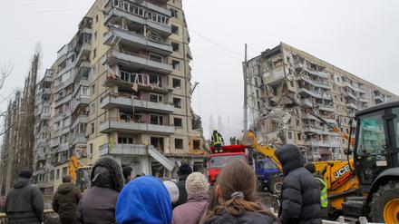 Menschen beobachten eine Such- und Rettungsaktion in dem Wohnblock in Dnipro, der von einer Rakete getroffen wurde (Archivbild).