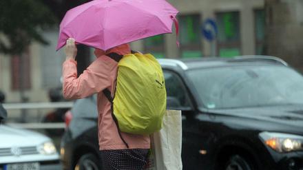 Wasseralarm. Eine Frau läuft am 30.Juni 2017 mit einem Regenschirm durch Berlin. 