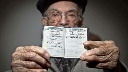 Hy Abrams, Überlebender, hat in einem Büchlein die Namen der Konzentrationslager eingetragen, in denen er von den Nazis inhaftiert worden war.