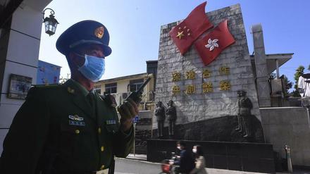 Ein chinesischer Polizist mit Schutzmaske steht in der Nähe der Grenze zu Hongkong.