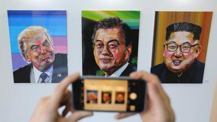 Ein Besucher fotografiert in einer Ausstellung in Seoul Bilder von US-Präsident Donald Trump, den südkoreanischen Präsidenten Moon Jae In und dem nordkoreanischen Führer Kim Jong Un.