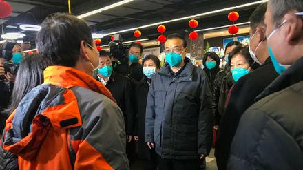 Chinas Regierungschef Li Keqiang (Mitte) spricht mit Bewohner der unter Quarantäne stehenden Stadt Wuhan. 