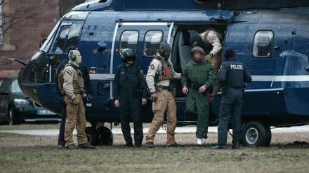 Beamte der Bundespolizei führen einen mutmaßliche Terrorverdächtigen aus einem Helikopter. 