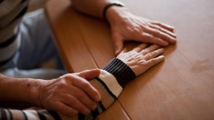 ARCHIV - 23.12.2011, ---: Ein Mann hält die Hand seiner Ehefrau, die an Alzheimer erkrankt ist. (zu dpa "BGH: Pflegegeld darf beim Pflegenden nicht gepfändet werden") Foto: Oliver Killig/dpa-Zentralbild/dpa +++ dpa-Bildfunk +++
