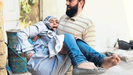 Erste Hilfe: Ein Kämpfer der „Freien Syrischen Armee“ bringt ein verletztes Mädchen in Sicherheit. Hubschrauber und Kampfflugzeuge der Armee bombardieren die nordsyrische Stadt Aleppo, die seit fünf Tagen heftig umkämpft ist. 