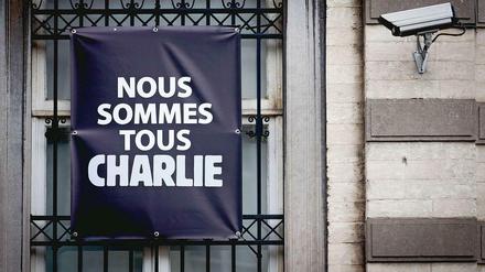 Protest und Überwachung. Am Fenster eines Hauses im belgischen Mons, an dem eine Überwachungskamera angebracht ist, ist die Botschaft "Wir alle sind Charlie" zu lesen.