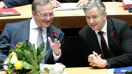 Der Regierende Bürgermeister, Klaus Wowereit (SPD, r), unterhält sich im Abgeordnetenhaus von Berlin mit Frank Henkel (CDU), Senator für Inneres und Sport. Zuvor hatten die neuen Senatoren ihren Amtseid abgelegt.