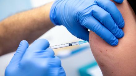 Ein Mitarbeiter der Asklepios Klinik in Bayern wird von einem Kollegen mit dem Corona-Impfstoff von Biontech/Pfizer geimpft. 